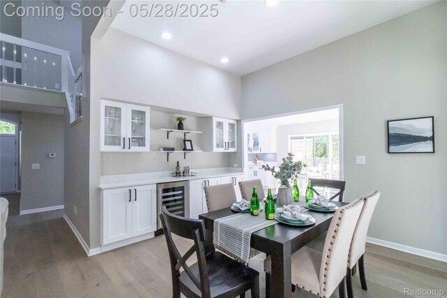 22170 Orchard Way, Beverly Hills, MI 48025 - dining area with beverage cooler, light wood finished floors, baseboards, plenty of natural light, and a towering ceiling
