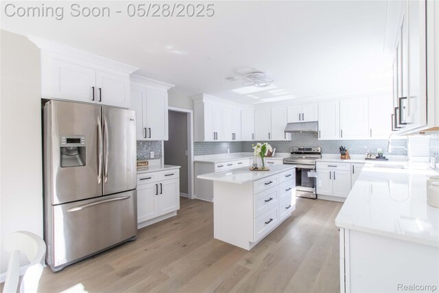 22170 Orchard Way, Beverly Hills, MI 48025 - kitchen with stainless steel appliances, under cabinet range hood, tasteful backsplash, a center island, and white cabinets