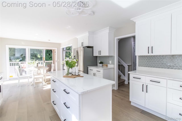 22170 Orchard Way, Beverly Hills, MI 48025 - kitchen featuring freestanding refrigerator, light wood-style floors, white cabinets, and backsplash