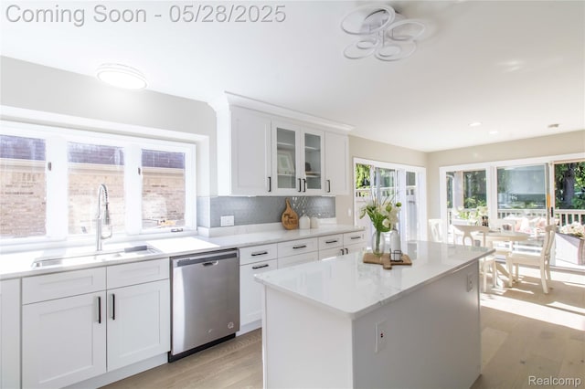 22170 Orchard Way, Beverly Hills, MI 48025 - kitchen featuring stainless steel dishwasher, a sink, light wood-style floors, white cabinets, and glass insert cabinets