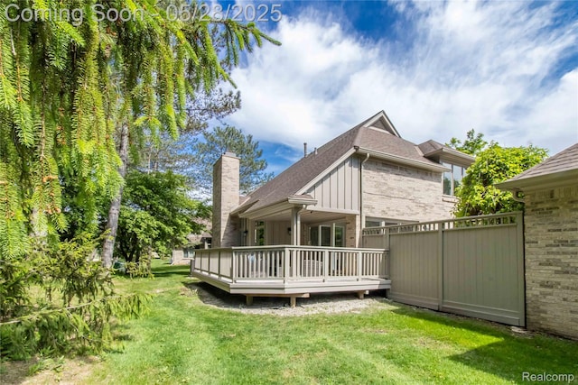 22170 Orchard Way, Beverly Hills, MI 48025 - back of house with a deck, brick siding, a chimney, roof with shingles, and board and batten siding