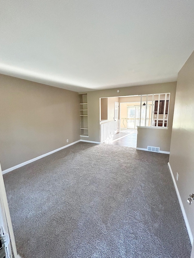 spare room featuring baseboards and carpet