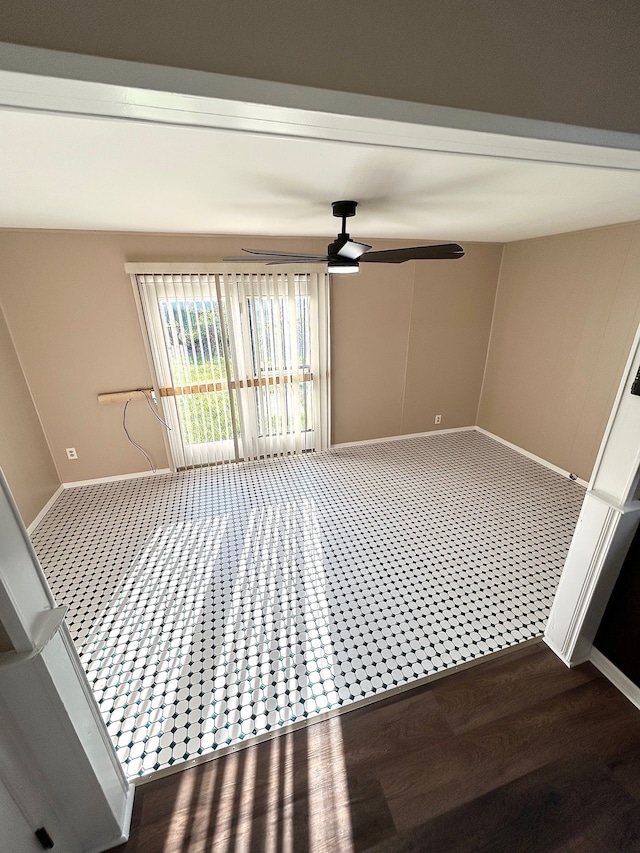 spare room featuring a ceiling fan, baseboards, and wood finished floors