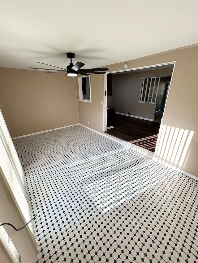 unfurnished room featuring ceiling fan and baseboards