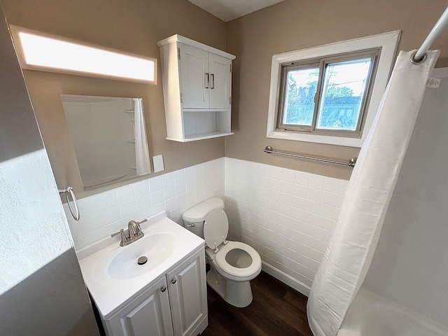 full bath with tile walls, curtained shower, toilet, vanity, and wood finished floors