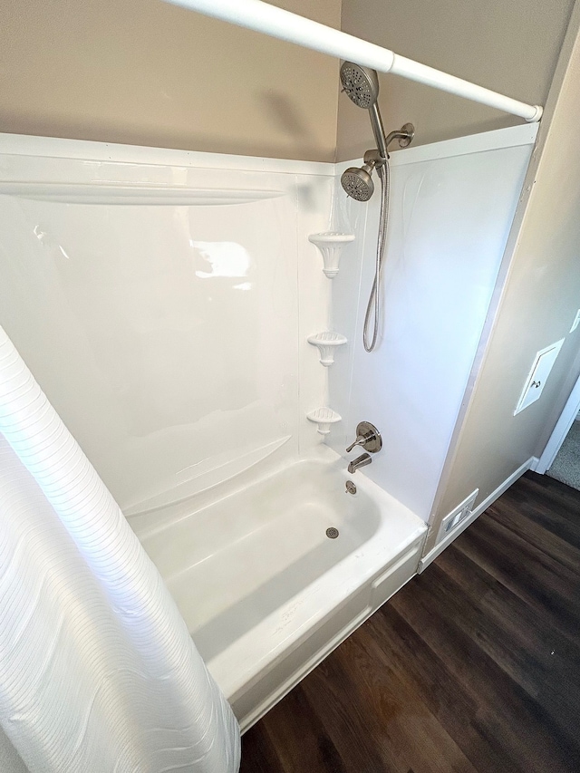 full bathroom with wood finished floors and shower / bathtub combination with curtain