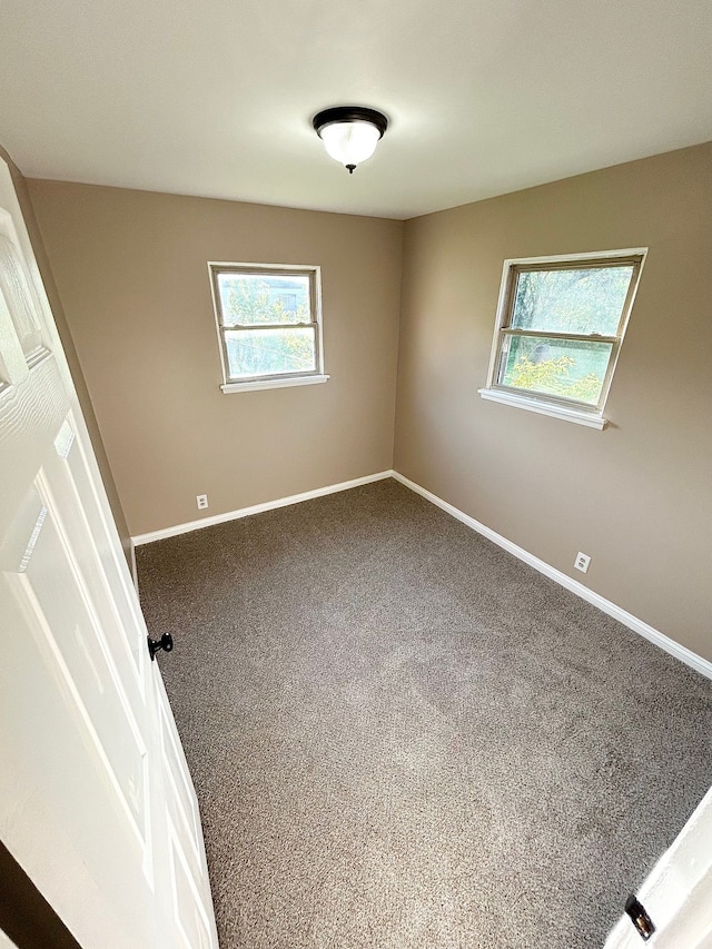 unfurnished room featuring baseboards and carpet flooring