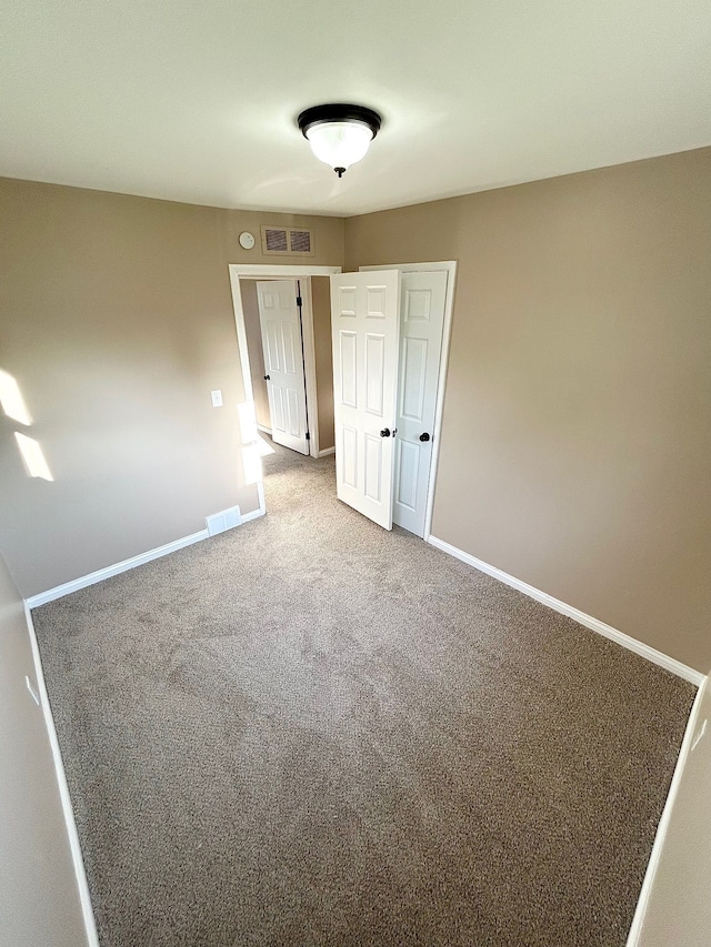spare room featuring carpet flooring and baseboards