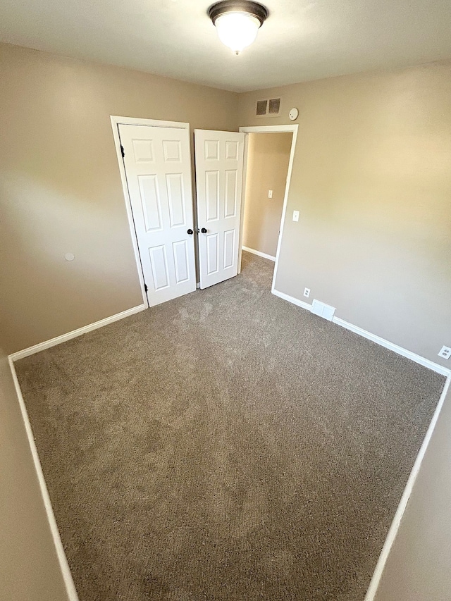unfurnished bedroom with baseboards, a closet, and carpet floors