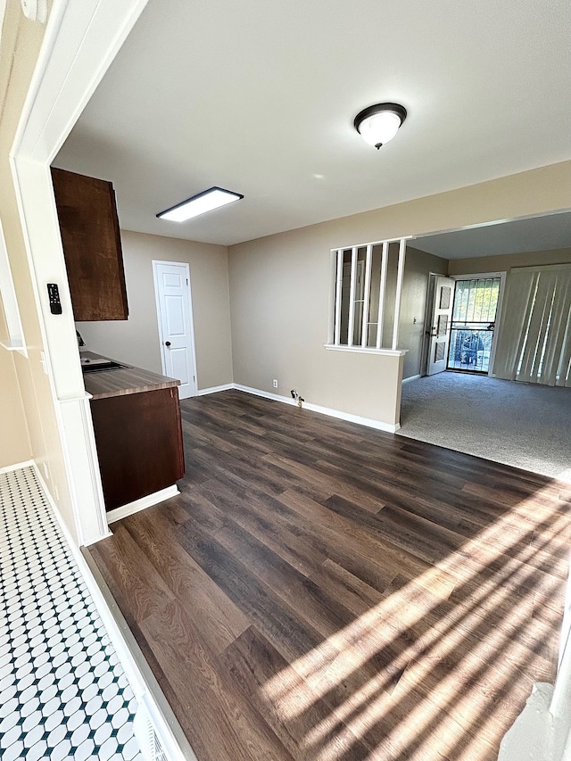 unfurnished living room with baseboards and wood finished floors