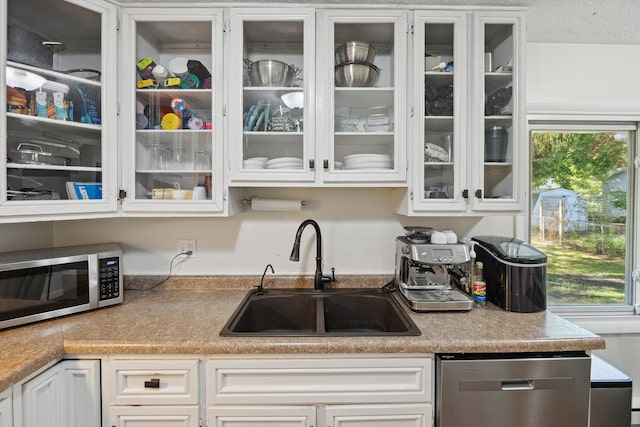 1008 Park St, Tecumseh, MI 49286 - kitchen featuring appliances with stainless steel finishes, a sink, glass insert cabinets, and white cabinets