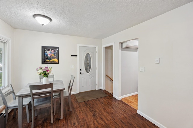 1008 Park St, Tecumseh, MI 49286 - dining area with an AC wall unit, wood finished floors, baseboards, and a textured ceiling