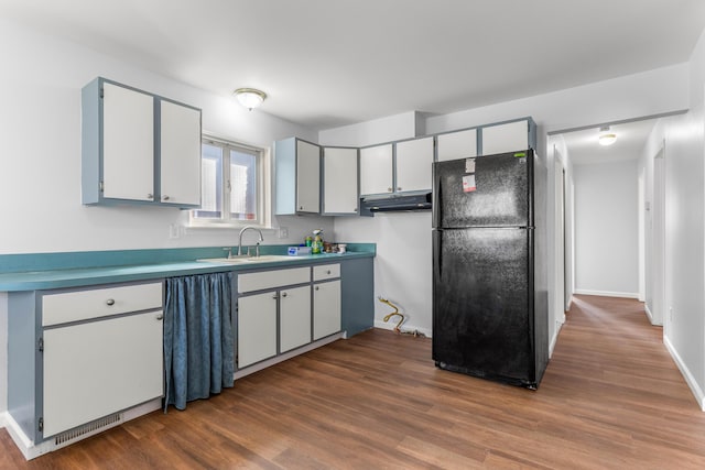 15945 Horger Ave, Allen Park, MI 48101 - kitchen with freestanding refrigerator, a sink, under cabinet range hood, dark wood finished floors, and light countertops
