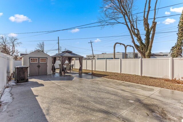 15945 Horger Ave, Allen Park, MI 48101 - view of patio featuring a gazebo, a fenced backyard, a storage unit, and an outbuilding