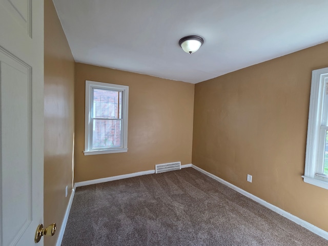 19415 Riopelle St, Highland Park, MI 48203 - empty room featuring dark colored carpet, plenty of natural light, and baseboards
