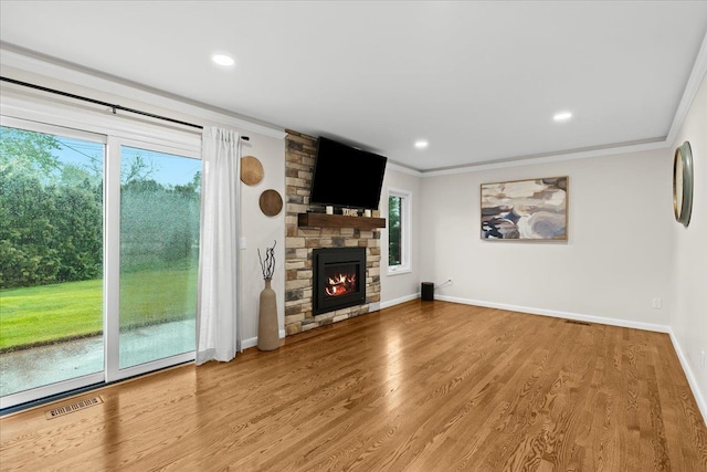 6557 N Twindale, Shelby Twp, MI 48316 - unfurnished living room with ornamental molding, a stone fireplace, baseboards, wood finished floors, and recessed lighting