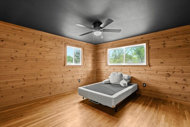 6557 N Twindale, Shelby Twp, MI 48316 - bedroom featuring light wood-style flooring, wood walls, and a ceiling fan