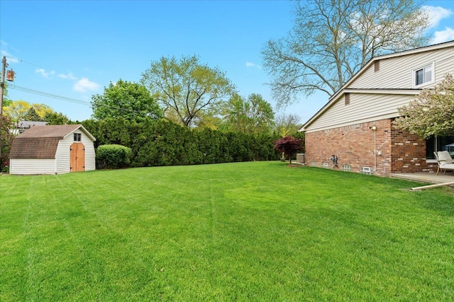 6557 N Twindale, Shelby Twp, MI 48316 - view of grassy yard with a shed, an outbuilding, and a patio area