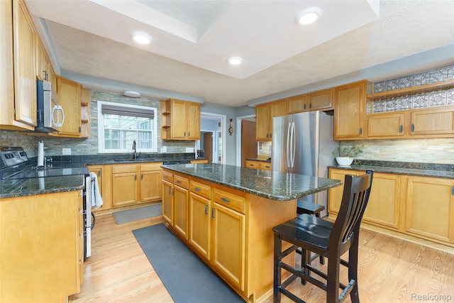 835 W Marr Rd, Howell, MI 48855 - kitchen with open shelves, appliances with stainless steel finishes, light wood-style flooring, a sink, and a kitchen island