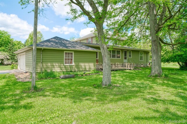 835 W Marr Rd, Howell, MI 48855 - back of property with a lawn, asphalt driveway, and a shingled roof