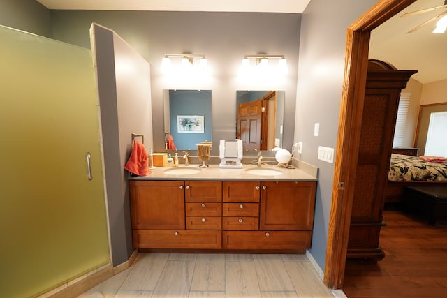 12161 Ladd Rd, Brooklyn, MI 49230 - ensuite bathroom featuring double vanity, wood finished floors, baseboards, ceiling fan, and an enclosed shower