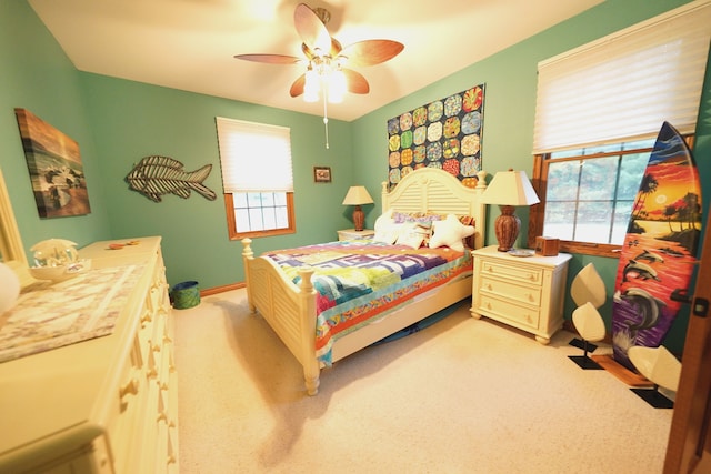 12161 Ladd Rd, Brooklyn, MI 49230 - bedroom with multiple windows, light colored carpet, a ceiling fan, and baseboards