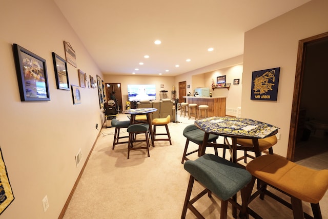 12161 Ladd Rd, Brooklyn, MI 49230 - dining space featuring recessed lighting, light carpet, bar, and baseboards