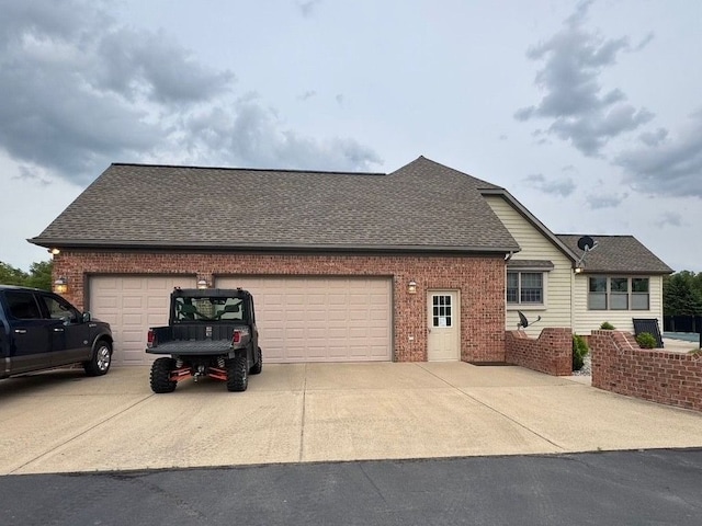 12161 Ladd Rd, Brooklyn, MI 49230 - view of side of property featuring driveway, brick siding, an attached garage, and roof with shingles