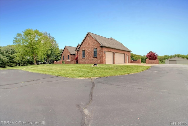 12161 Ladd Rd, Brooklyn, MI 49230 - view of property exterior featuring brick siding, a garage, and a yard