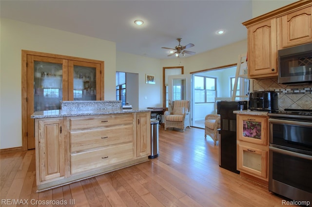12161 Ladd Rd, Brooklyn, MI 49230 - kitchen with appliances with stainless steel finishes, light brown cabinets, light wood-style floors, tasteful backsplash, and light stone countertops