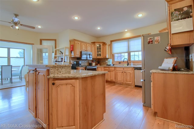 12161 Ladd Rd, Brooklyn, MI 49230 - kitchen with stainless steel appliances, ceiling fan, a sink, light wood-style floors, and glass insert cabinets