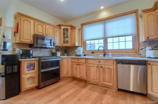 12161 Ladd Rd, Brooklyn, MI 49230 - kitchen with appliances with stainless steel finishes, a sink, light brown cabinets, tasteful backsplash, and light wood-style flooring