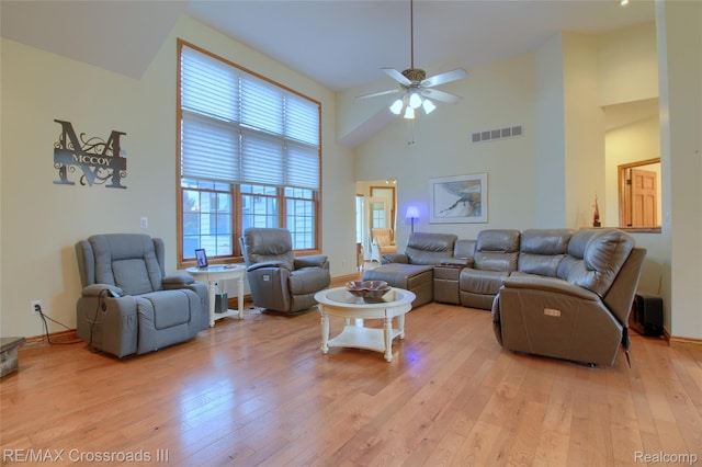 12161 Ladd Rd, Brooklyn, MI 49230 - living room featuring light wood-style flooring, a ceiling fan, plenty of natural light, a high ceiling, and baseboards