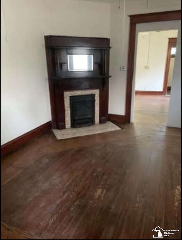 417 Harrison St, Monroe, MI 48161 - unfurnished living room featuring wood finished floors, a fireplace with flush hearth, and baseboards