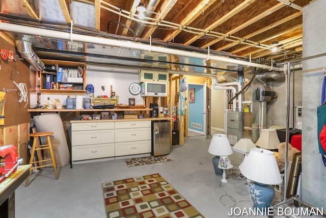 94 Cheyenne Ave, Holland, MI 49424 - unfinished basement with fridge, a workshop area, and heating unit
