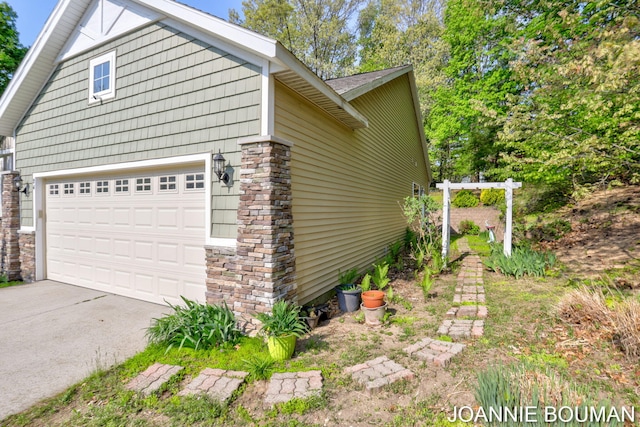94 Cheyenne Ave, Holland, MI 49424 - view of side of home with concrete driveway, a garage, and stone siding