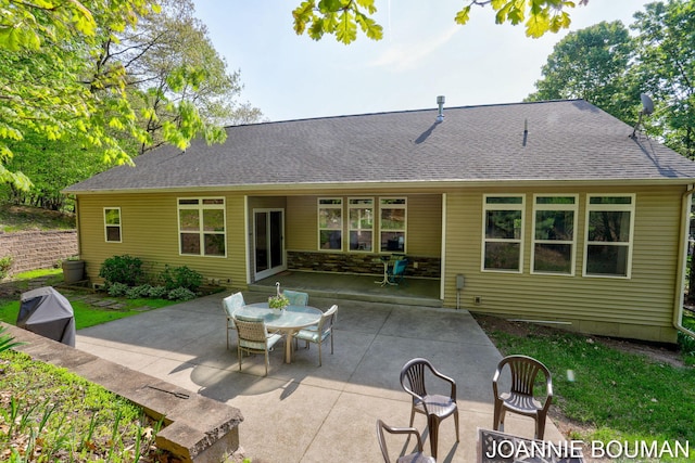 94 Cheyenne Ave, Holland, MI 49424 - back of house featuring a patio, a shingled roof, and outdoor dining space