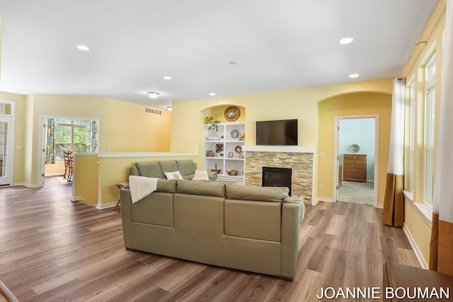 94 Cheyenne Ave, Holland, MI 49424 - living area with wood finished floors, recessed lighting, a fireplace, baseboards, and arched walkways