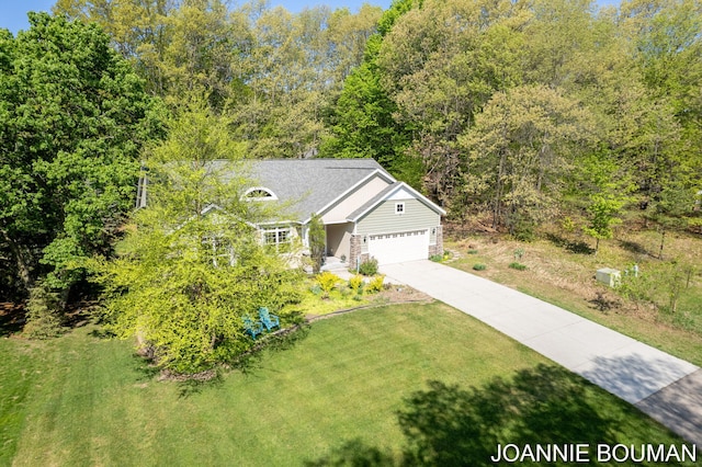 94 Cheyenne Ave, Holland, MI 49424 - view of front of home with a front lawn, concrete driveway, a garage, and a view of trees