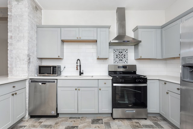 2514 Lothrop St, Detroit, MI 48206 - kitchen featuring appliances with stainless steel finishes, wall chimney range hood, a sink, and gray cabinetry
