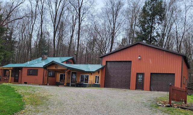 16545 Lonesome Trl, Leroy, MI 49655 - view of front of home with gravel driveway, metal roof, a chimney, and a porch