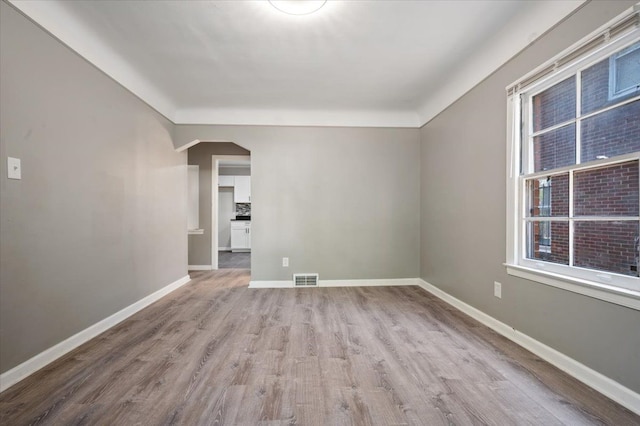 18611 Pinehurst St, Detroit, MI 48221 - spare room with wood finished floors, arched walkways, and baseboards