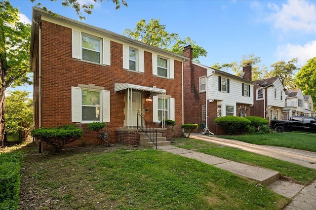 18611 Pinehurst St, Detroit, MI 48221 - view of front of home featuring a front lawn, brick siding, and a chimney
