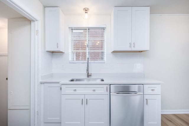 kitchen with a sink, light countertops, tasteful backsplash, and white cabinets