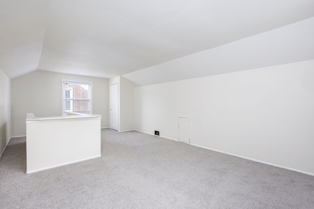bonus room with lofted ceiling, light carpet, and baseboards