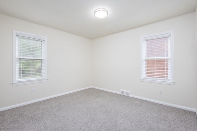 carpeted empty room with baseboards