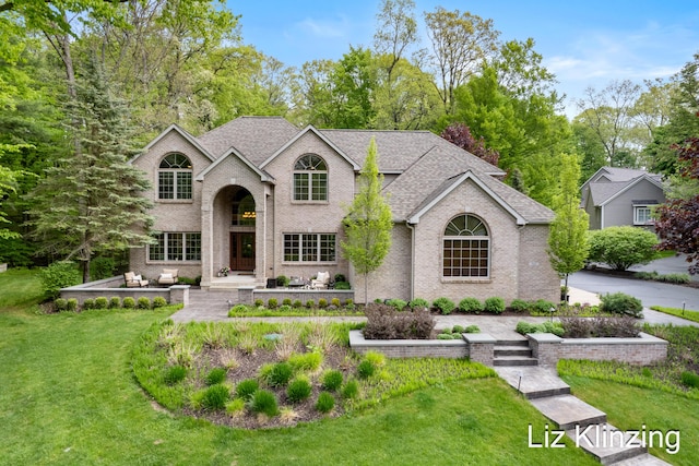 966 Timber Winds Dr SW, Grand Rapids, MI 49534 - traditional-style house with brick siding, a front yard, and a shingled roof