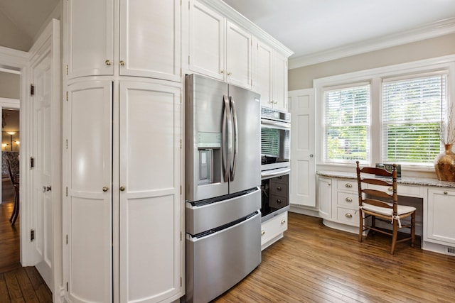 602 N Kalamazoo Ave, Marshall, MI 49068 - kitchen with appliances with stainless steel finishes, white cabinetry, light wood-style flooring, crown molding, and light stone countertops