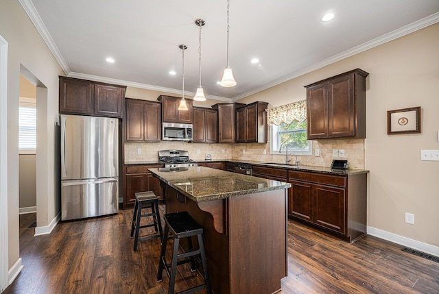 2380 Avalon Woods Dr, Portage, MI 49024 - kitchen with stainless steel appliances, a sink, dark brown cabinets, a center island, and a breakfast bar area