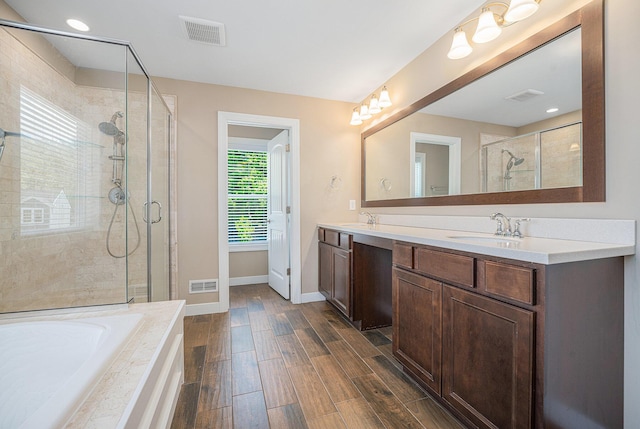 2380 Avalon Woods Dr, Portage, MI 49024 - full bathroom featuring a stall shower, a garden tub, double vanity, baseboards, and wood finished floors
